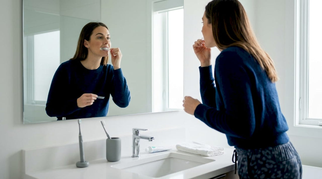 Woman applying teeth whitening strip at home