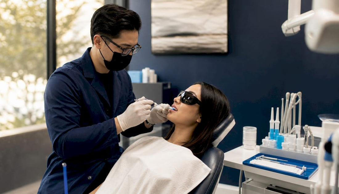 Dentist applying teeth whitening gel in dental clinic
