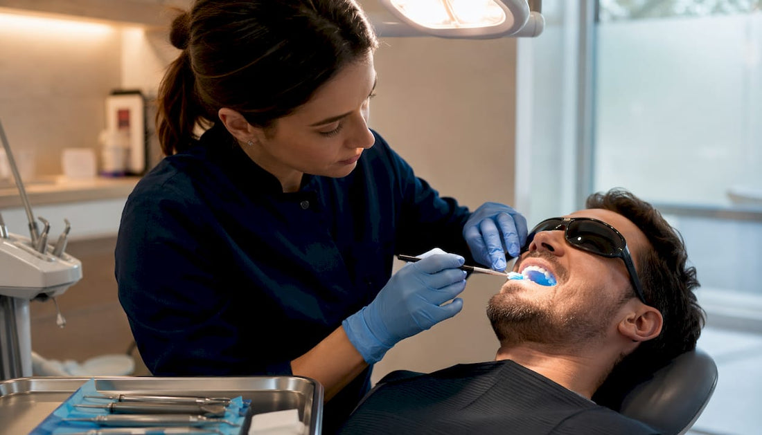 Dentist applying whitening gel to patient's teeth