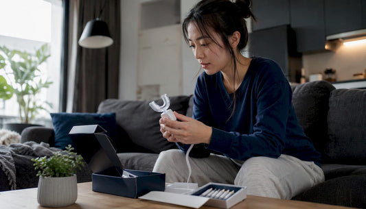 Woman using at-home teeth whitening kit
