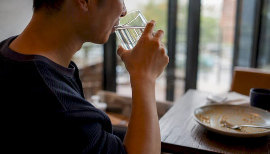 Hand holding a glass of water for mouth rinse