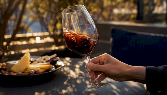 Hand swirling red wine glass at table