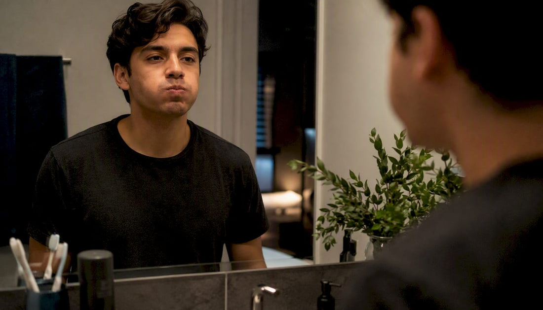 Person rinsing mouth with mouthwash in bathroom
