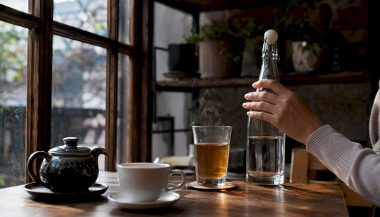 Person reaching for water after drinking tea