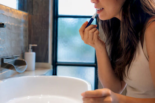 Hands applying teeth whitening serum