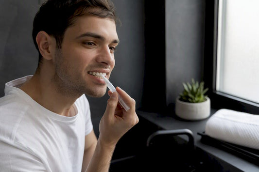 Hands applying whitening gel on teeth