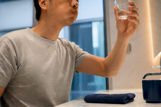 Adult using whitening mouthwash at bathroom sink